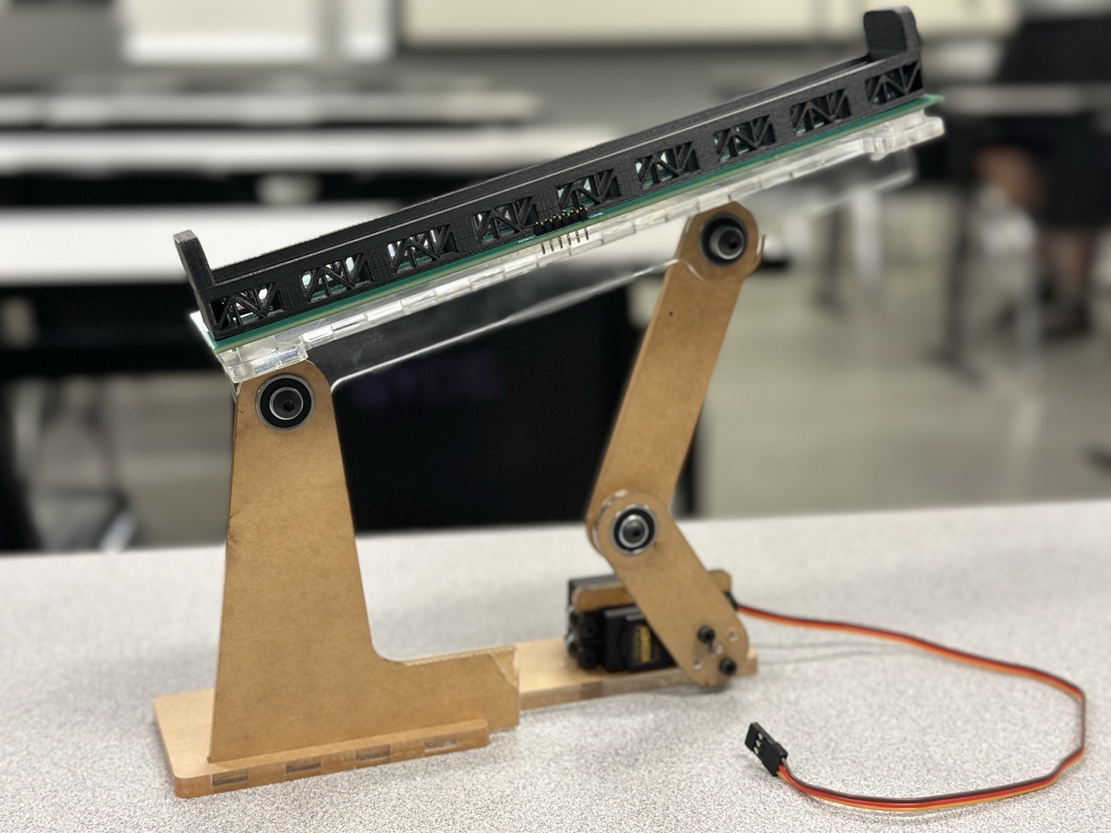 Finished ball balancing beam: CNC-cut acrylic tower and linkage, acrylic beam, sensor PCB, and black 3D-printed truss trough